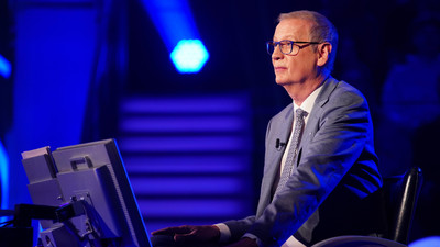 Günther Jauch sitzt im blauen Studio von Wer wird Millionär am Ratestuhl